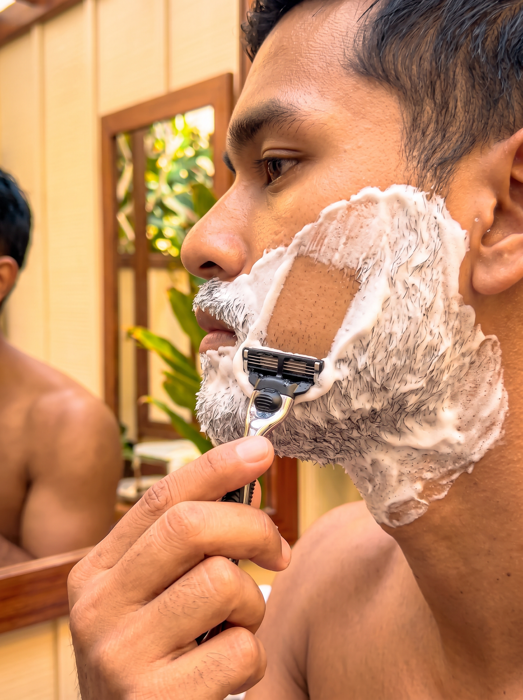 a male model mid shave using a natural shaving soap