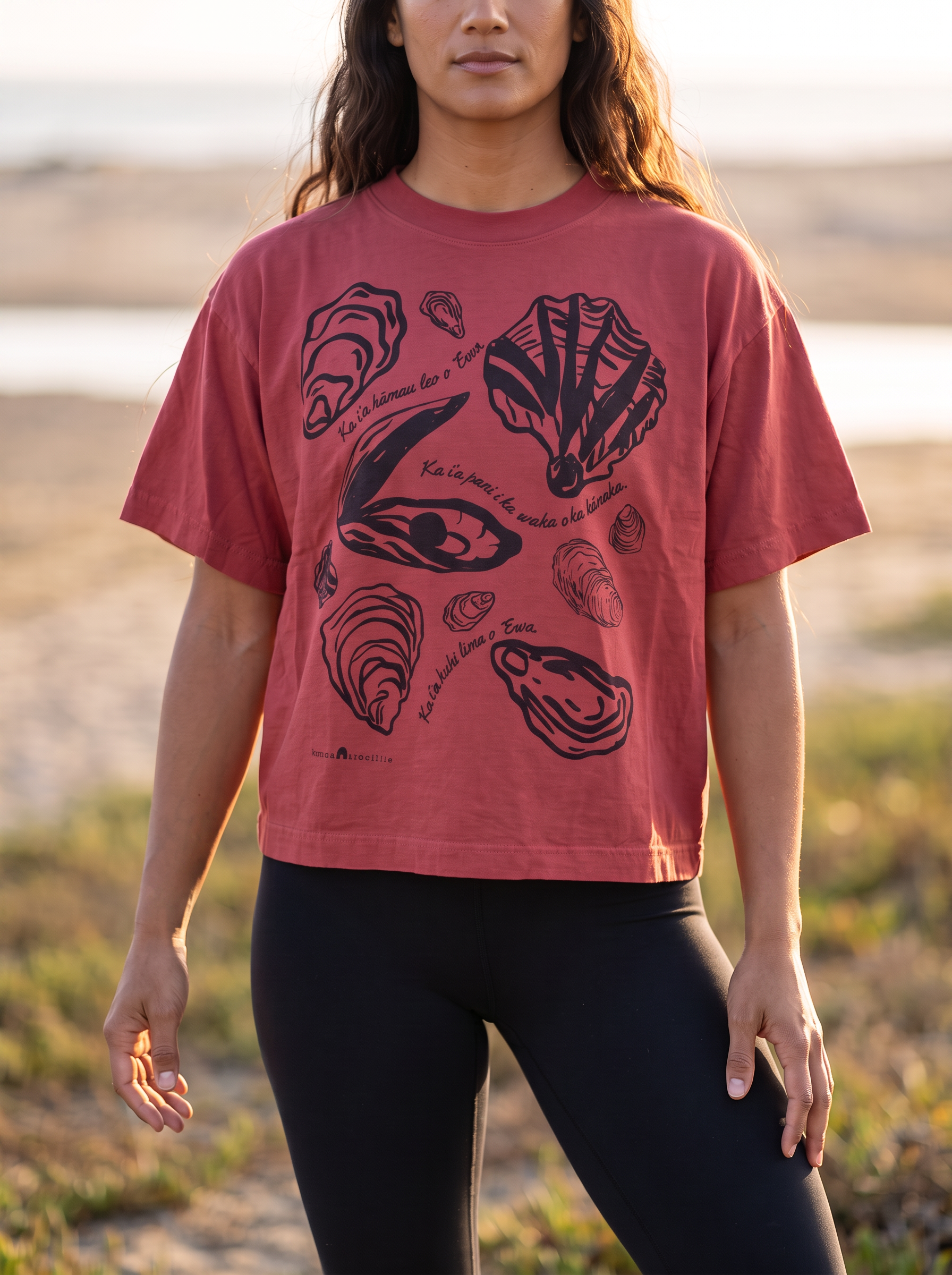 female model wearing crop style trash tee with Pipi Pearl Oyster design in black Algae Ink in the color, deep coral.
