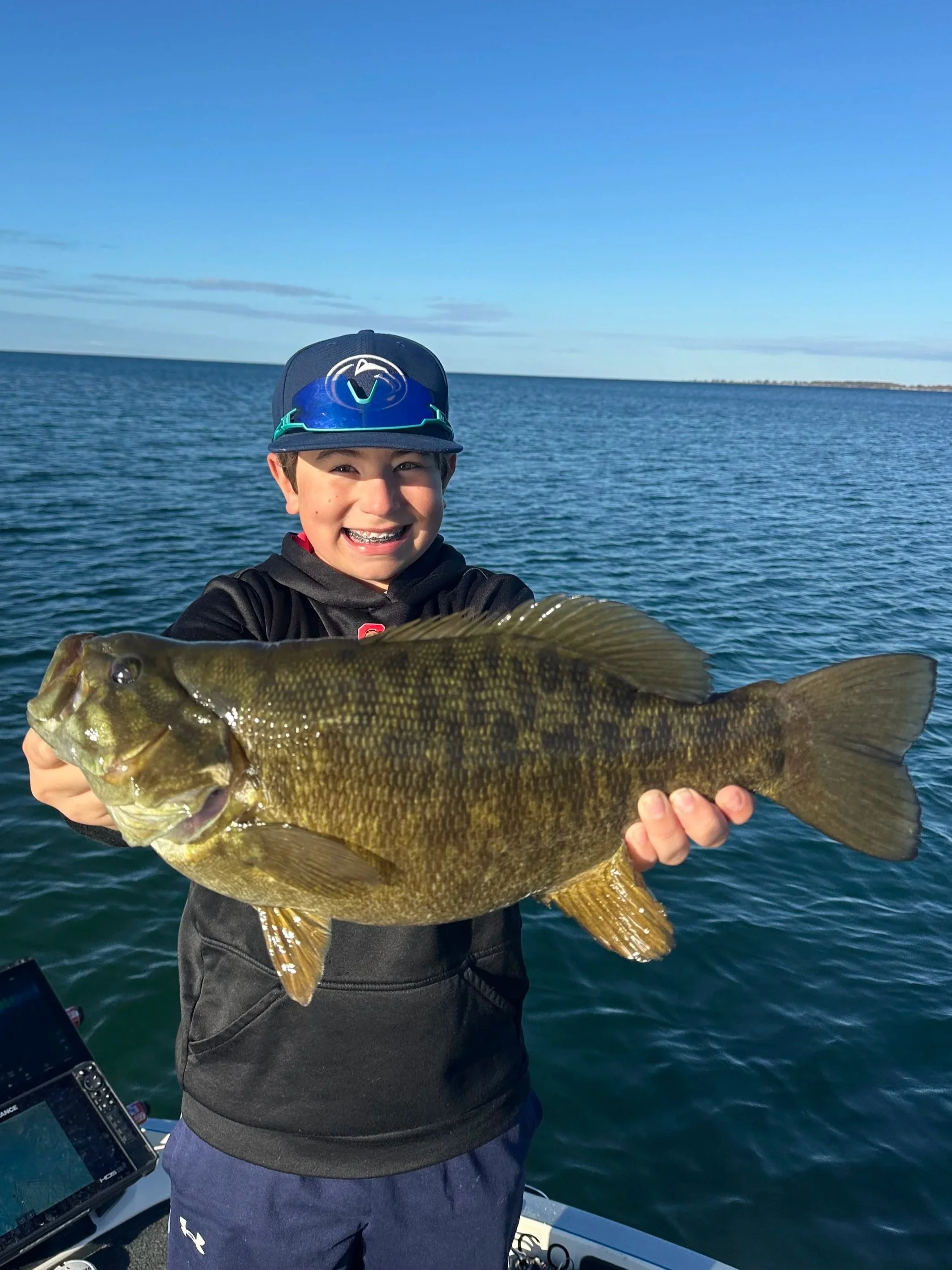 Young kid catches biggest smallmouth of his life on guide trip smiling