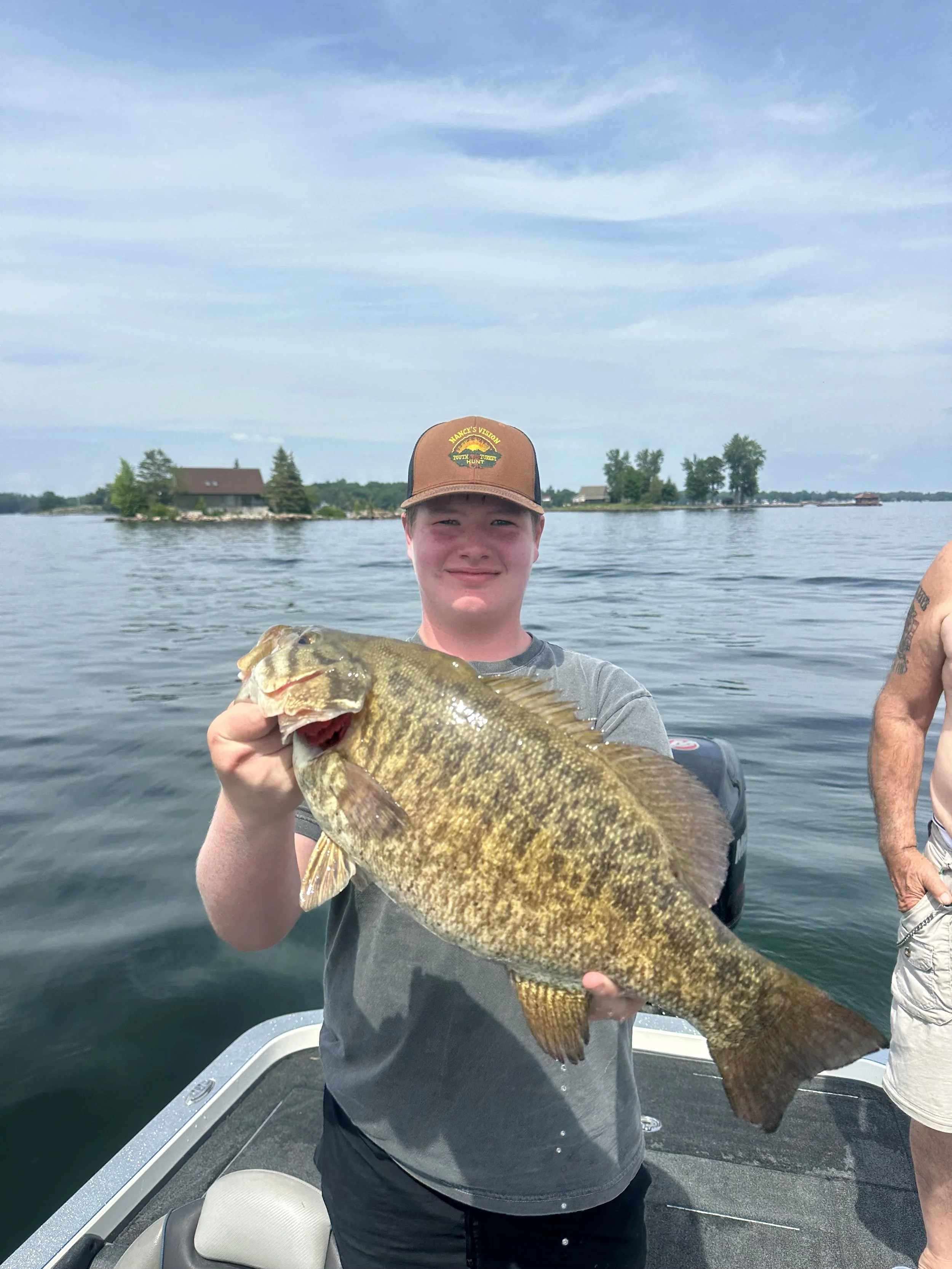 Young angler smiling fishing for big Smallmouth bass 