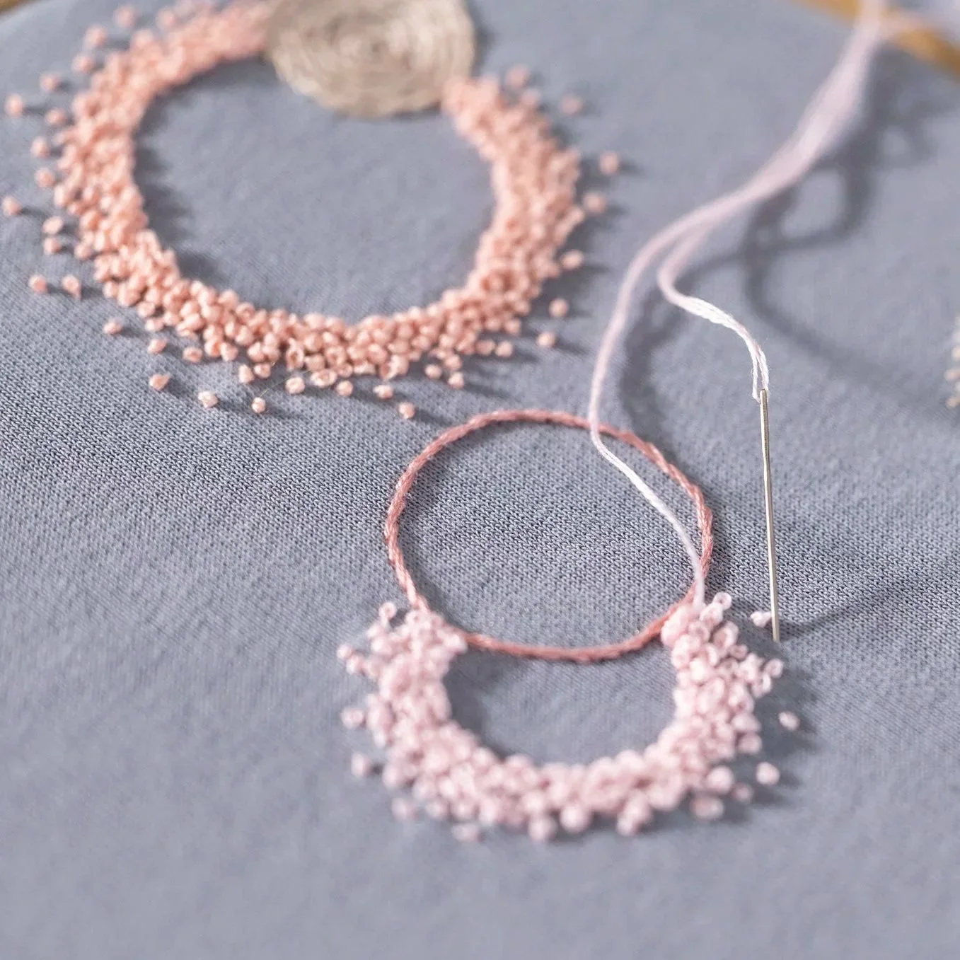 rosa Knoetchenstich auf hellblauem Sweatshirt