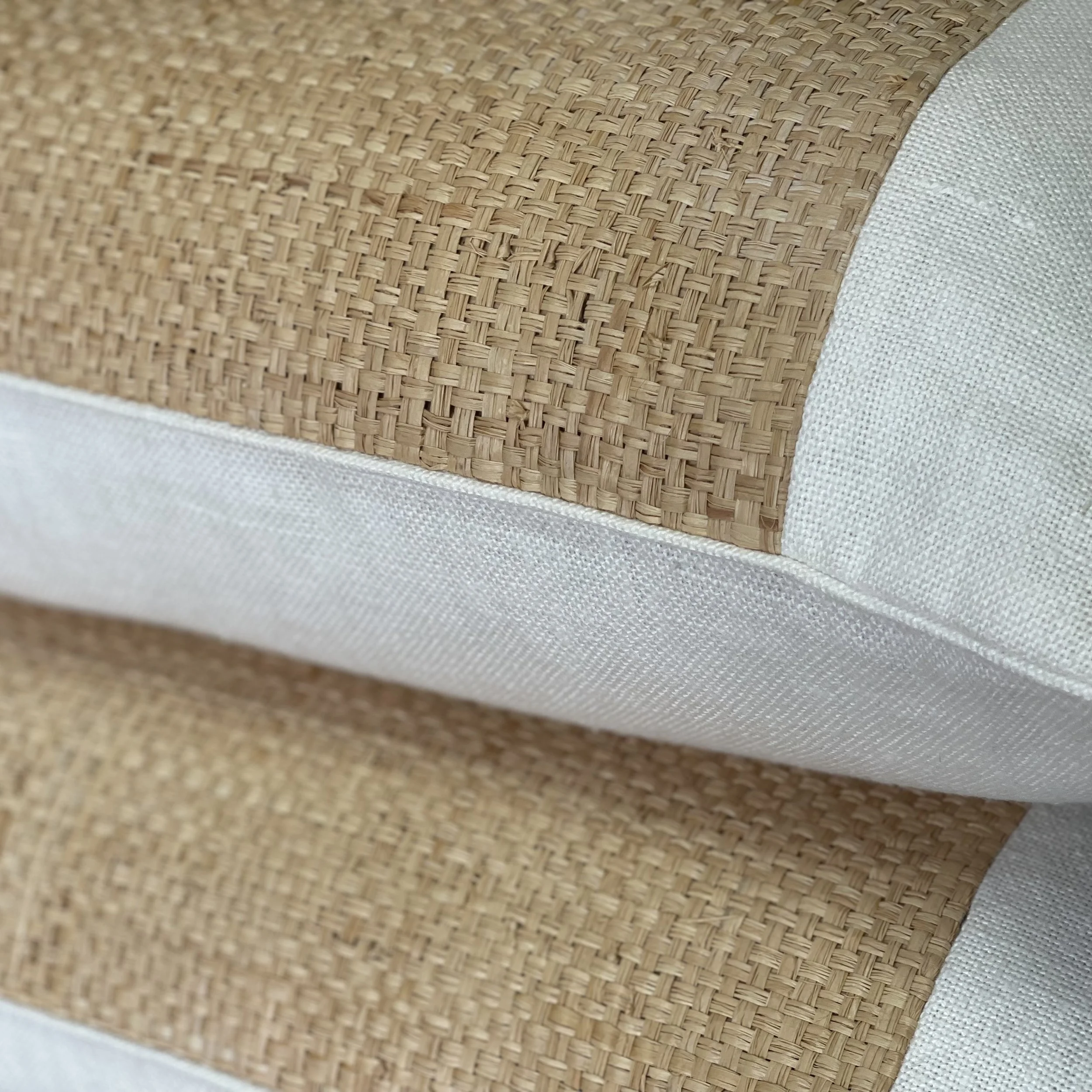Close-up of a woven, wicker-textured object with a fabric border, possibly part of furniture or decor.