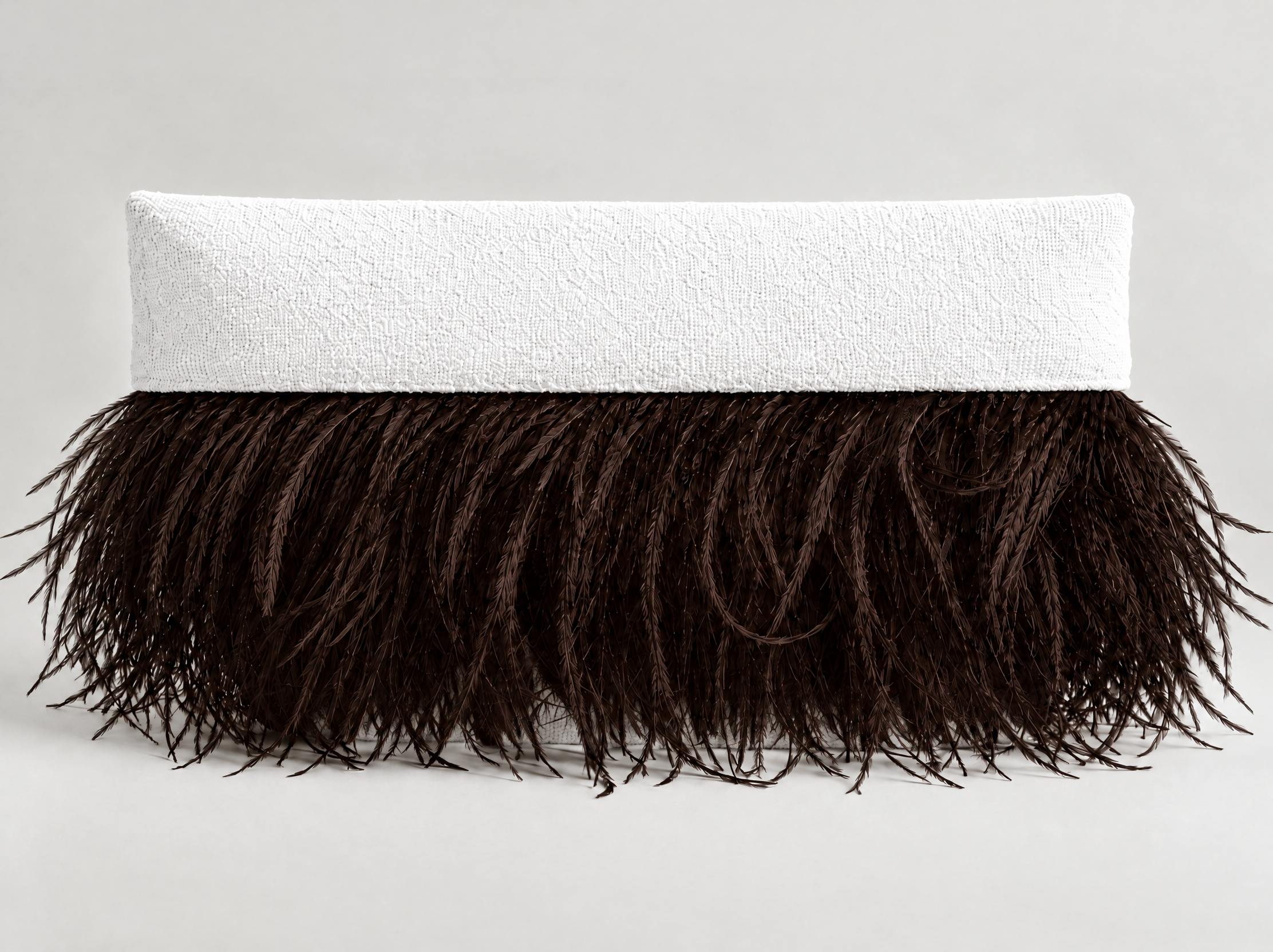 A round, layered table with a white textured top and a dark brown feathered base, set against a plain light background.