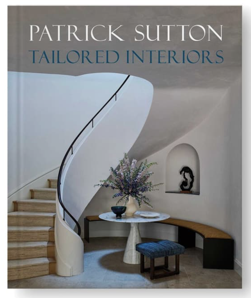 A book titled "Tailored Interiors" by Patrick Sutton, featuring a modern interior with a curved staircase, a small round table with a floral arrangement, a bench, and decorative wall art.