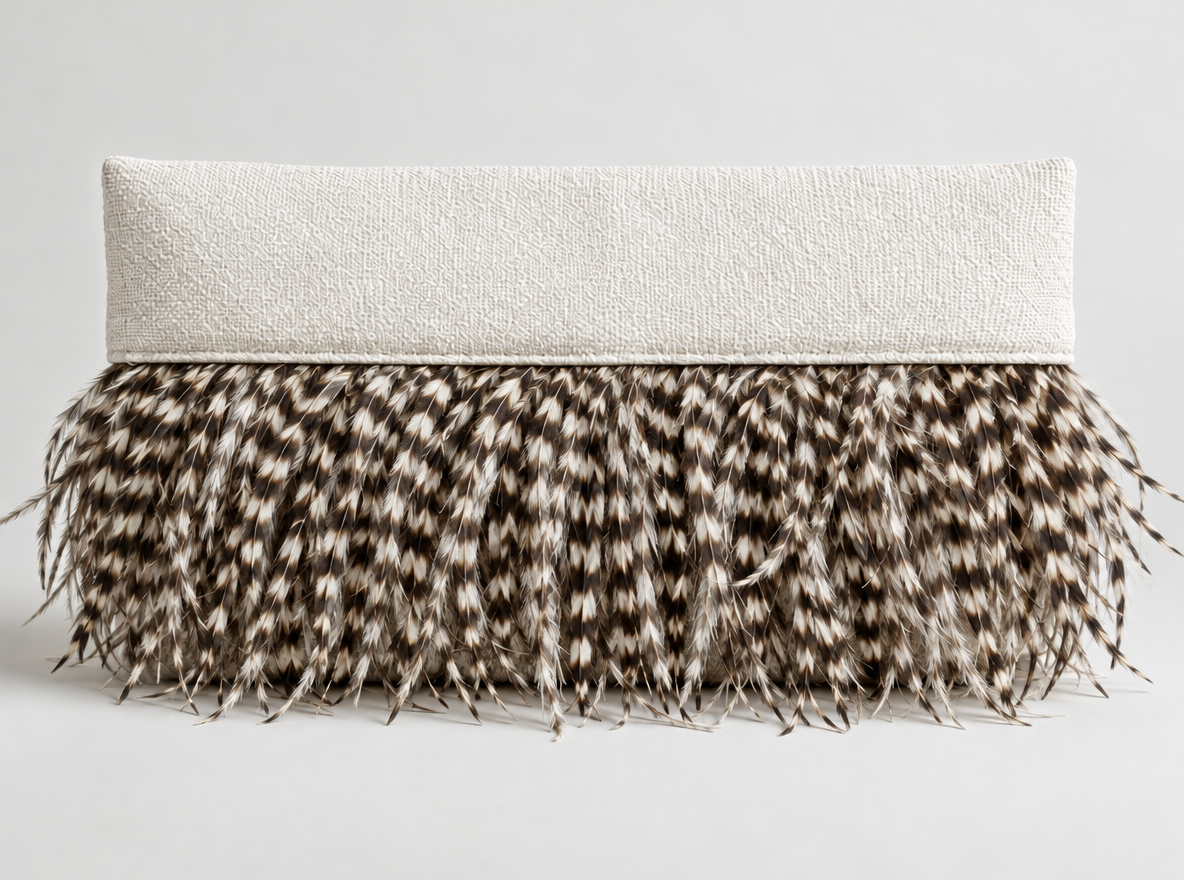 Decorative cushion with a white textured top and a base covered in brown, black, and white patterned feathers.