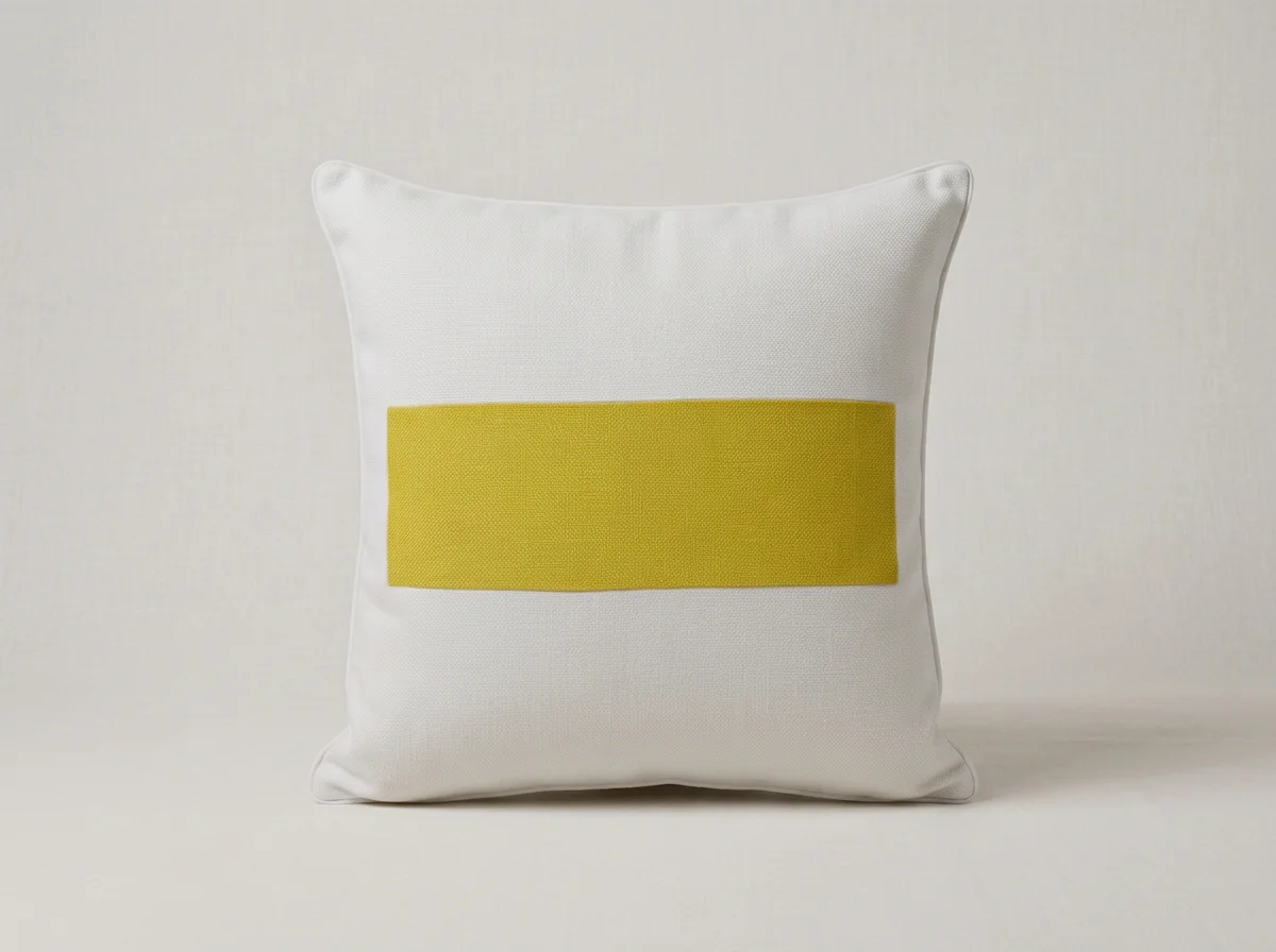 White Italian linen Après pillows with a citrine burlap dash design in the center. placed against a plain light-colored background.