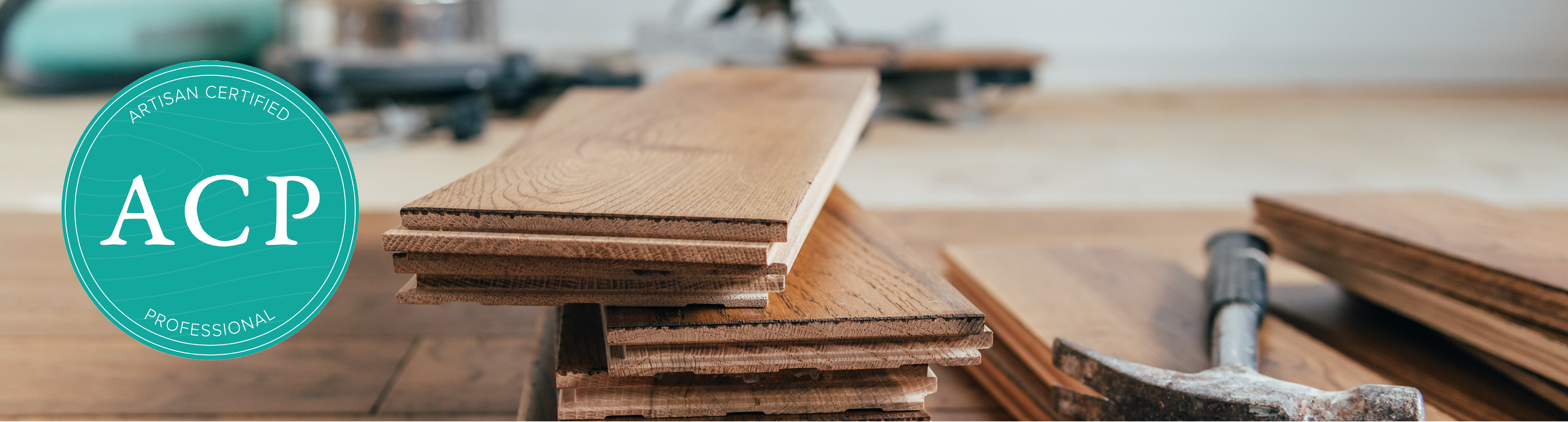 Stacks of wooden planks on a workbench with a hammer nearby, in a woodworking shop.