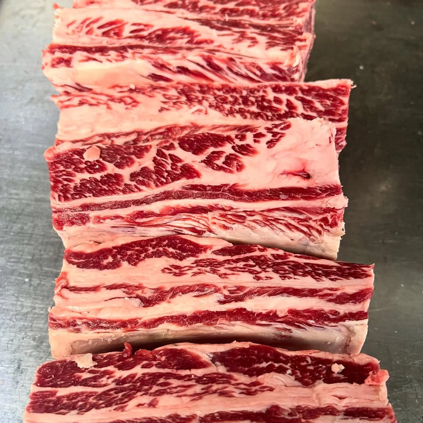 Let’s talk ribs! Whether you’re firing up the grill or slow-braising all day, we’ll cut your ribs exactly how you like them.
~Whole plate- 3 ribs intact, bold and meaty
~Flanken-style-thin-sliced for Korean BBQ perfection.
~Cut int