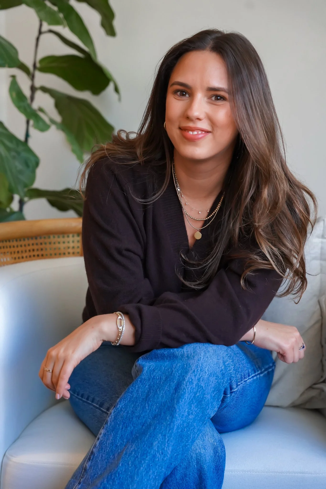 Lindsay Cohen-Weingarten, West LA therapist, sitting in rattan arm chair with potted plant in the background