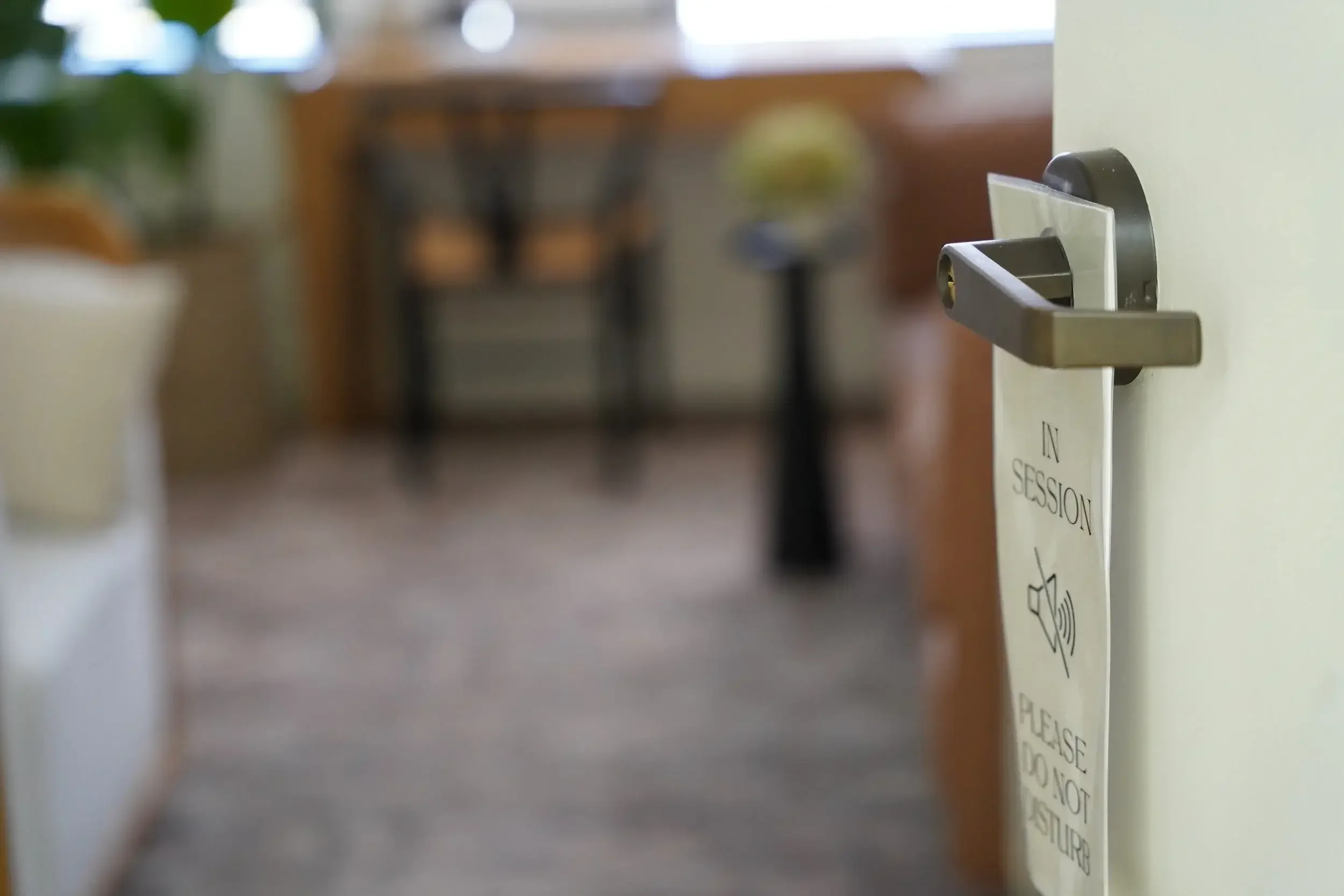 opened therapy office door with a "do not disturb" sign on the door handle