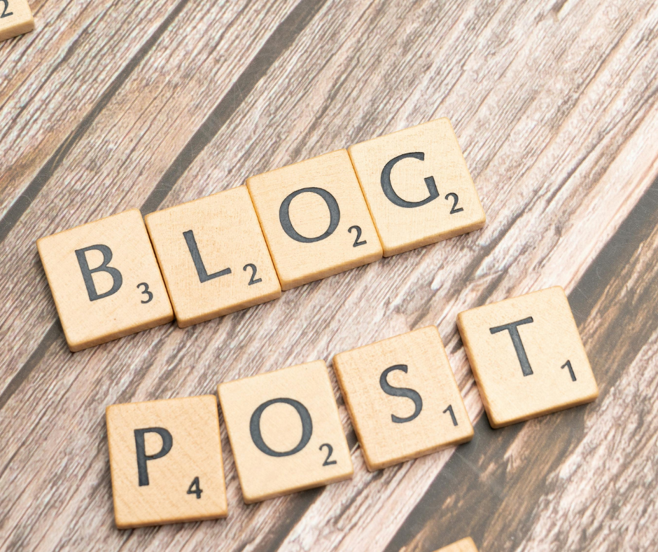 Scrabble tiles spelling out 'BLOG' and 'POST' on a wooden surface.
