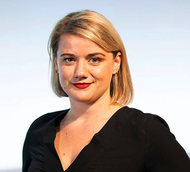 A young woman with blonde hair, wearing a black top and red lipstick, looking at the camera with a slight smile.