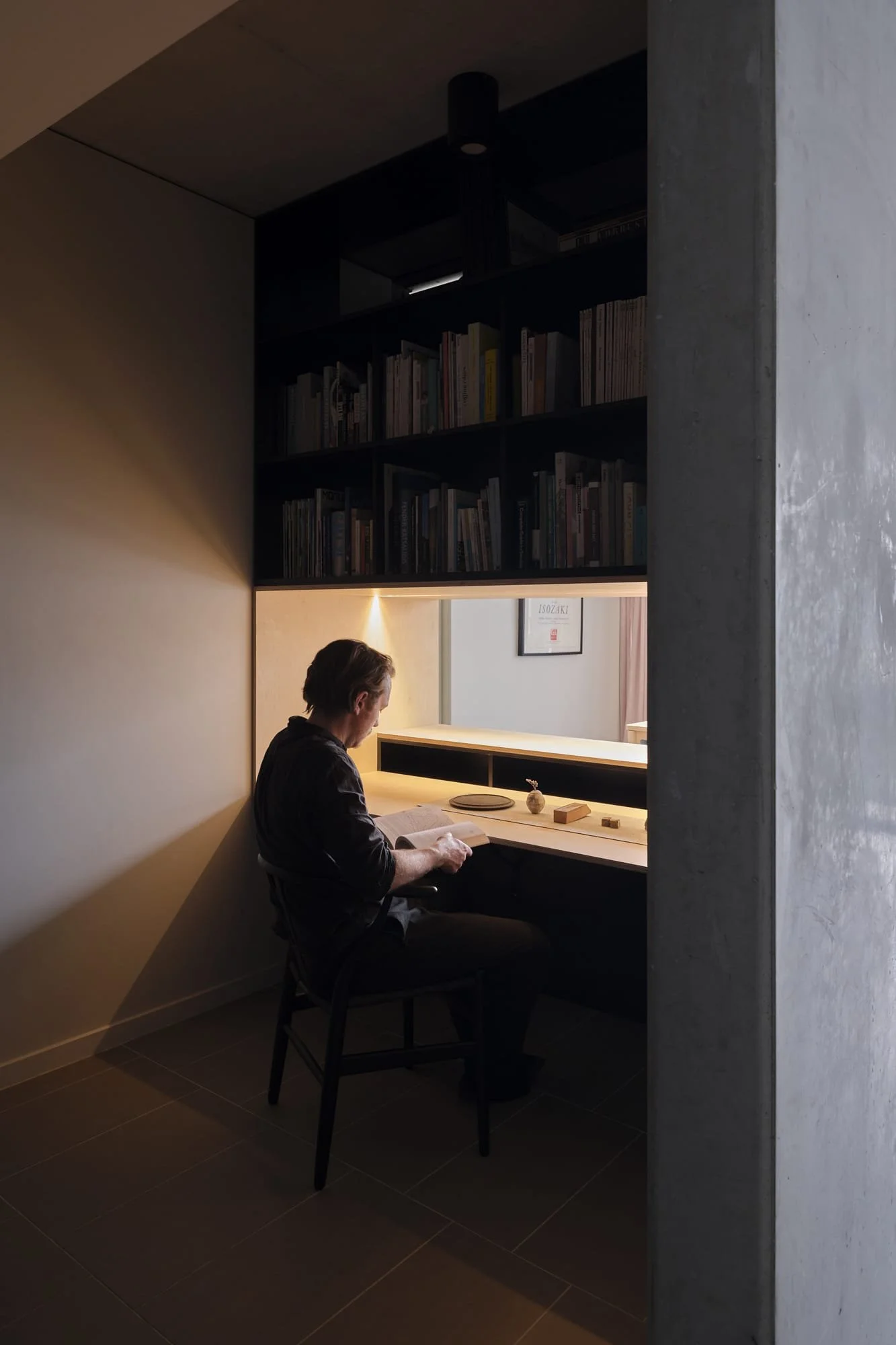 Bespoke home office joinery in Kingston, Canberra, featuring a natural plywood desk and integrated black shelving by Asmbl.