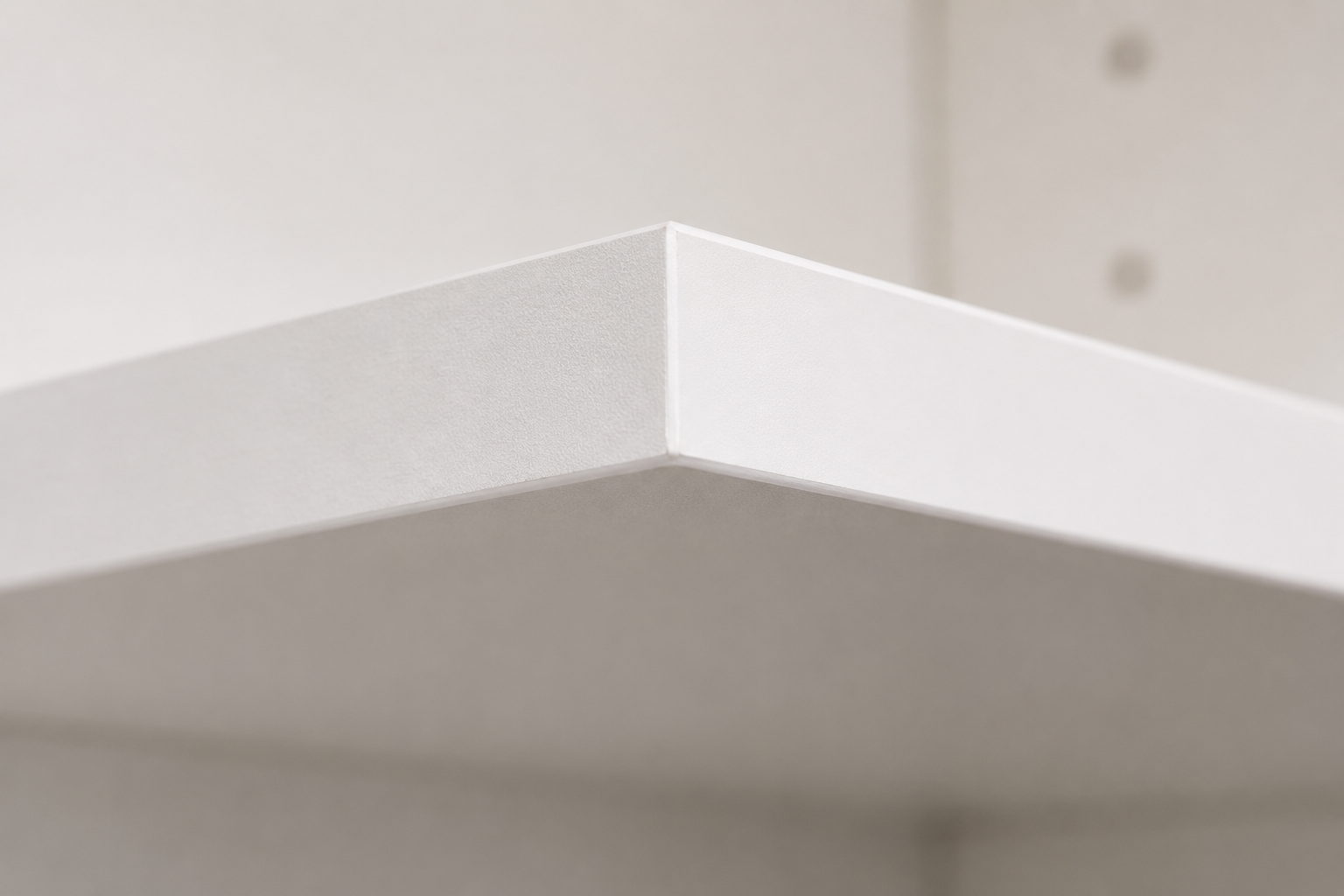 Close-up of 16mm white HMR melamine shelf corner showing precision PVC edge banding, ASMBL Joinery Canberra