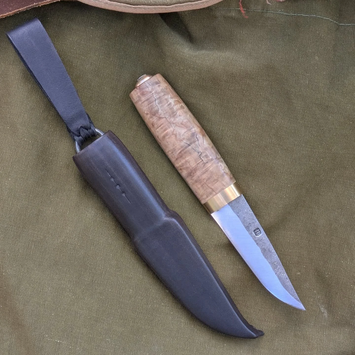 1/5 of the set that I made for the puukkosepp&auml; (puukkosmith) qualification.

Puukko that is made for everyday use. 

Stenco leuku blade with bearing bronze fittings, stabilized curly birch handle. Sheath is veg. tan cow hide with wooden insert a