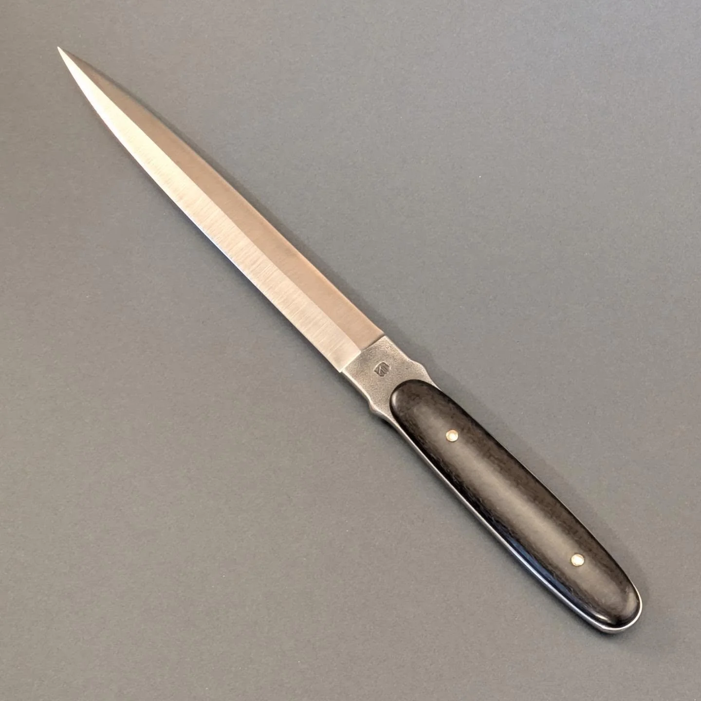Dagger.
.
Stenco leuku blade and carbon fiber scales with brass pins.
.
.
.
#blacksmith #puukkosepp&auml;  #dagger