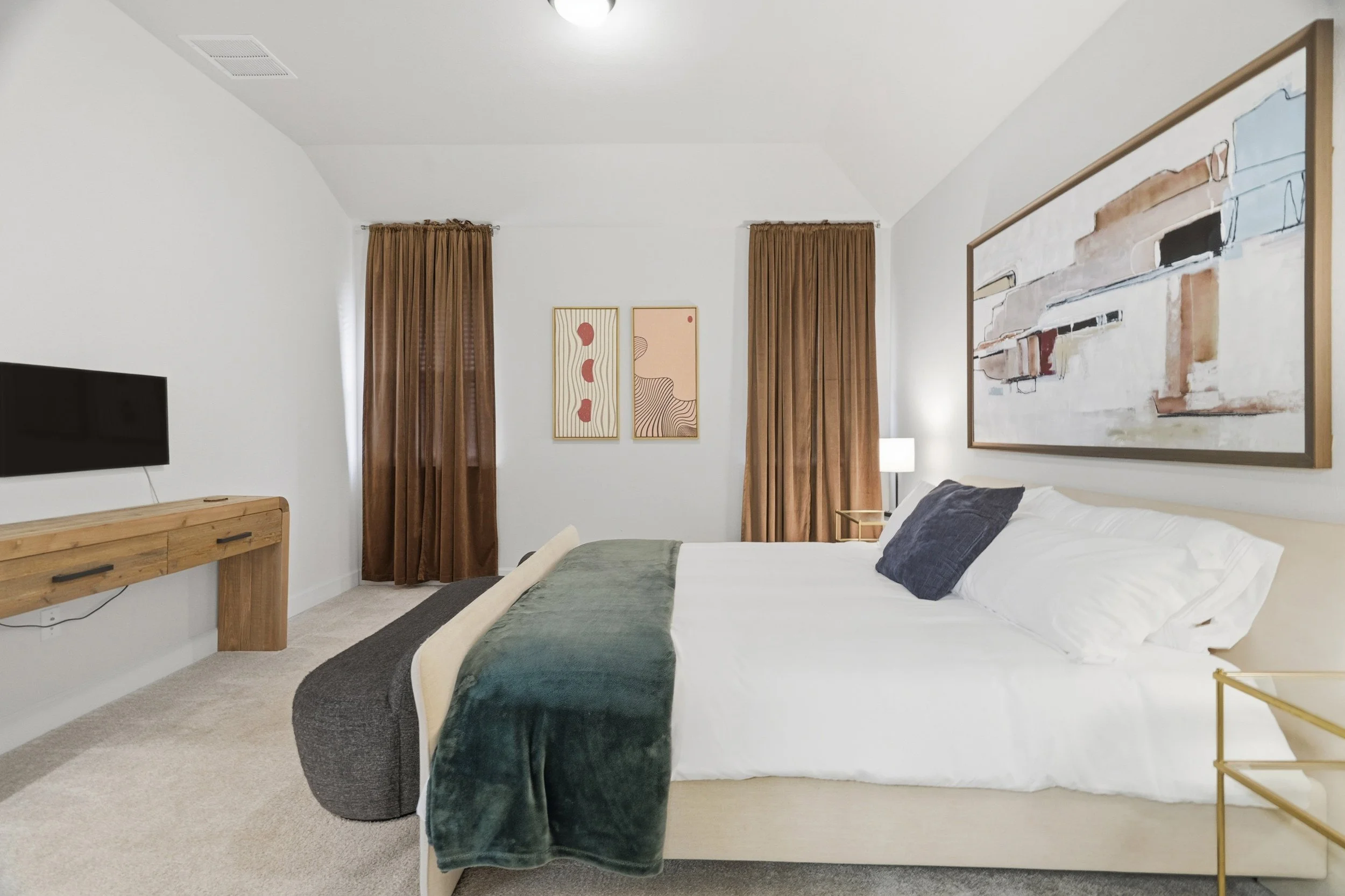 Primary bedroom with king bed, tv and window coverings.jpg