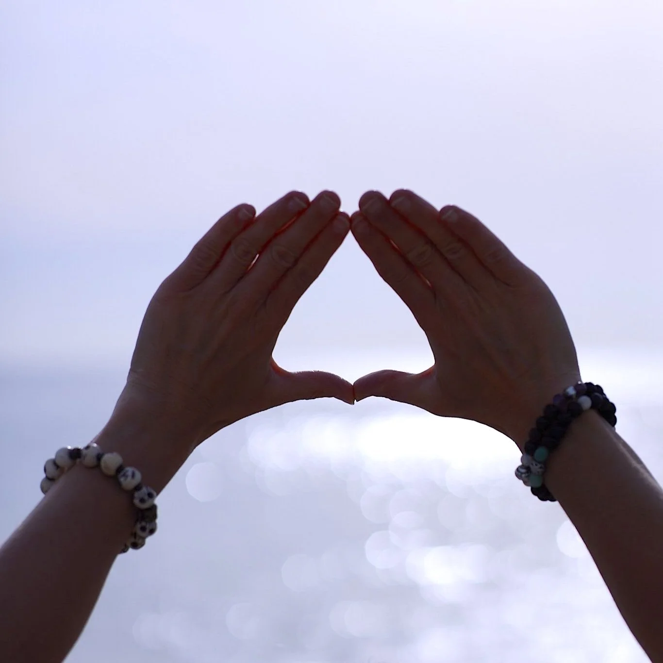 Trimurti mudra au bord de la mer au soleil levant pour se nourrir des énergies solaires malas aux poignets