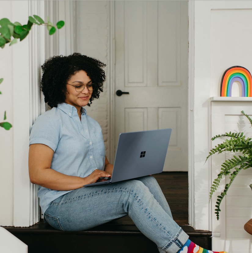 Queer woman with laptop smiling while watching a video course