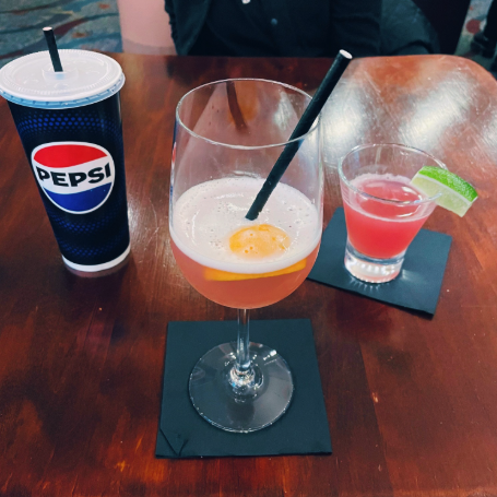 My event mocktail in a giant wine glass looking very much like an over-easy egg