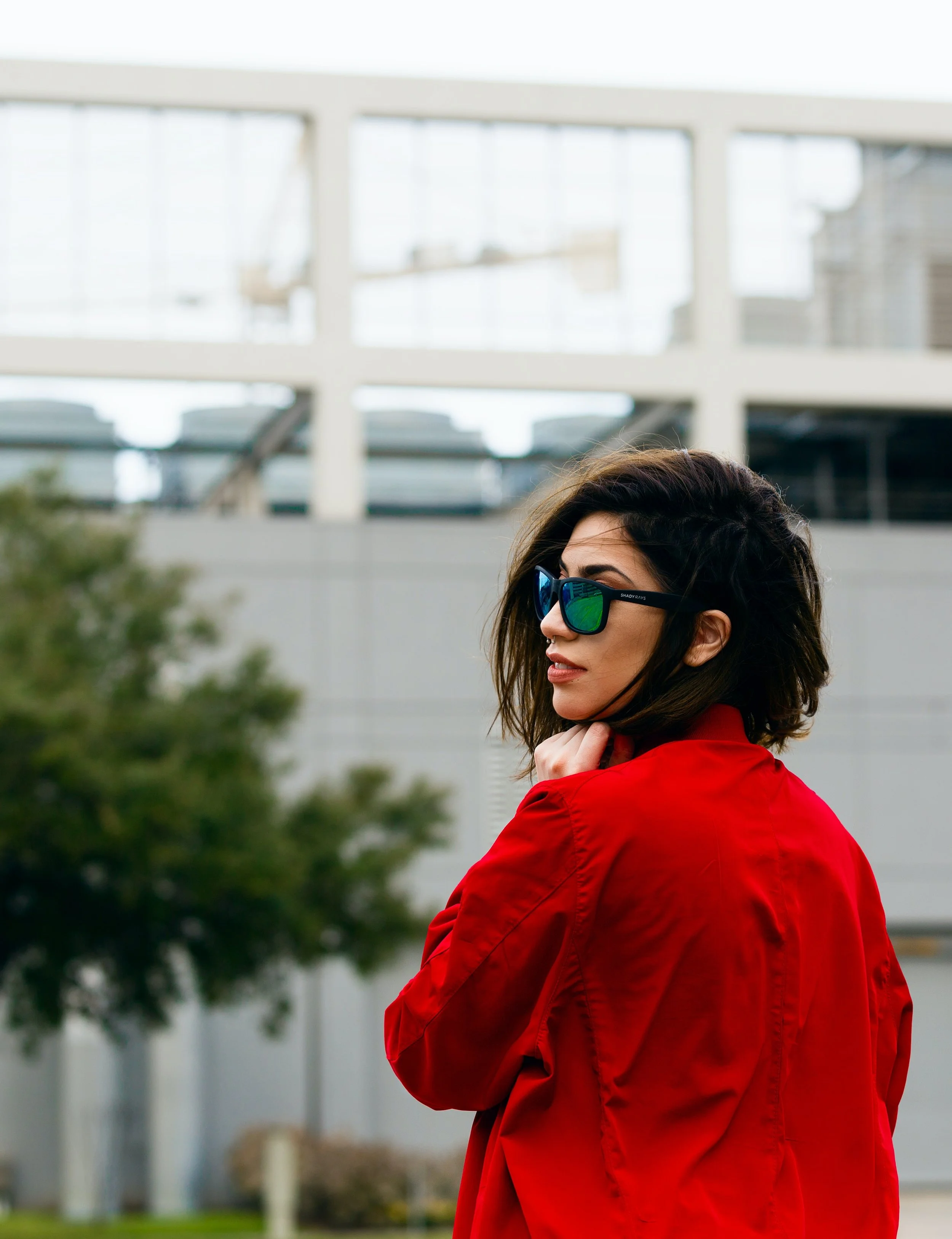 Woman wearing a red jacket and sunglasses looking cool for Sober October