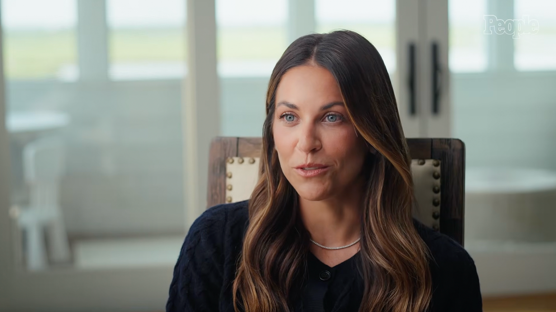 A woman with long brown hair seated for a People interview in a bright, softly lit room