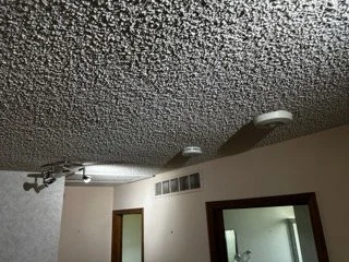 Close-up of a residential popcorn ceiling texture being inspected for asbestos-containing materials prior to a home renovation in Denver.