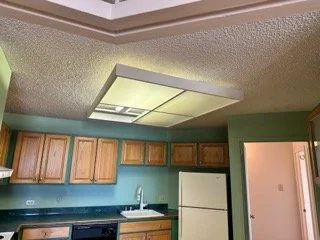 Asbestos testing of a popcorn ceiling in a kitchen area to ensure safety and permit compliance before a modern remodeling project.