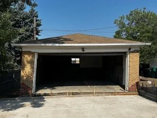 Inside a concrete floor residential garage in Denver, Colorado, being prepared for demolition and undergoing a pre-demolition asbestos inspection to sample wall and structural materials.