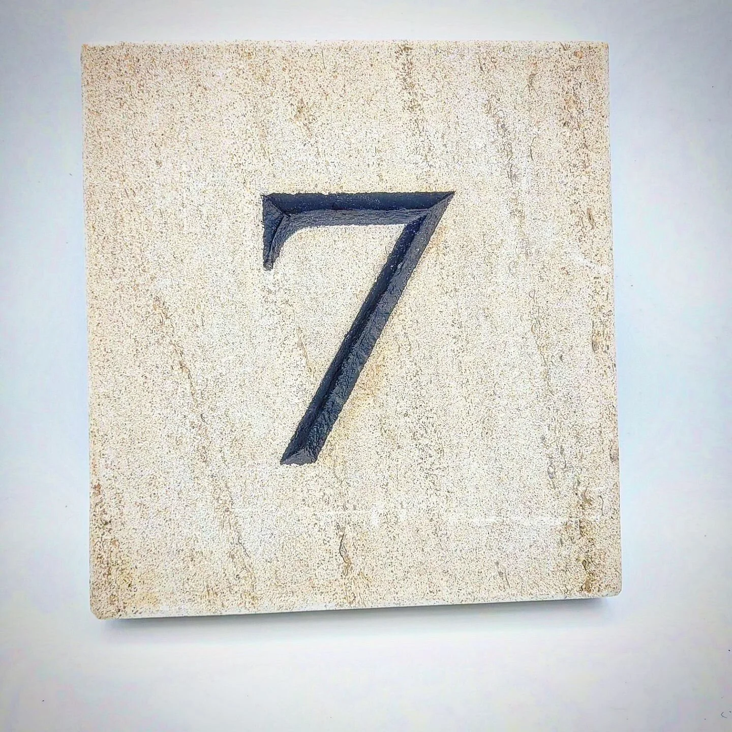 House number carved in limestone. Painted in black enamel.##housenumber #housenumbers #customhomes #customhome #stonemasons #stonemason ##masonry #mason #canadianartist #canadianart #craftsmanship #seven #carving #limestone #enamel #handcrafted #hand
