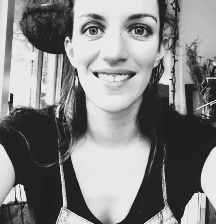 black and white artist portrait of Kira smiling at the viewer