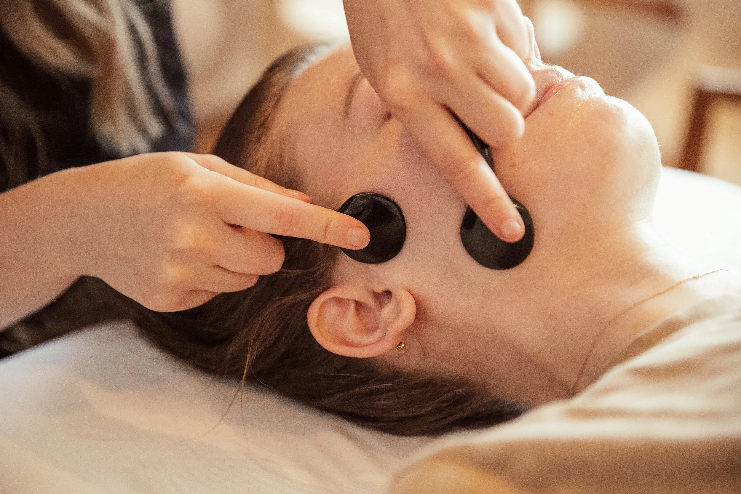 Woman receiving facial gua sha on jaw