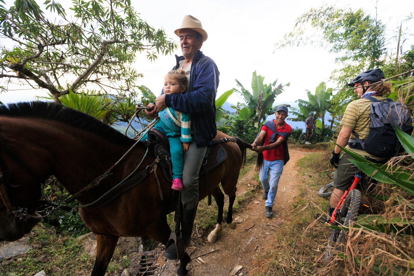 Campesinos make their daily commute home as Lucas Isakowitz (right) stays clear while mountain biking in Colombia.
