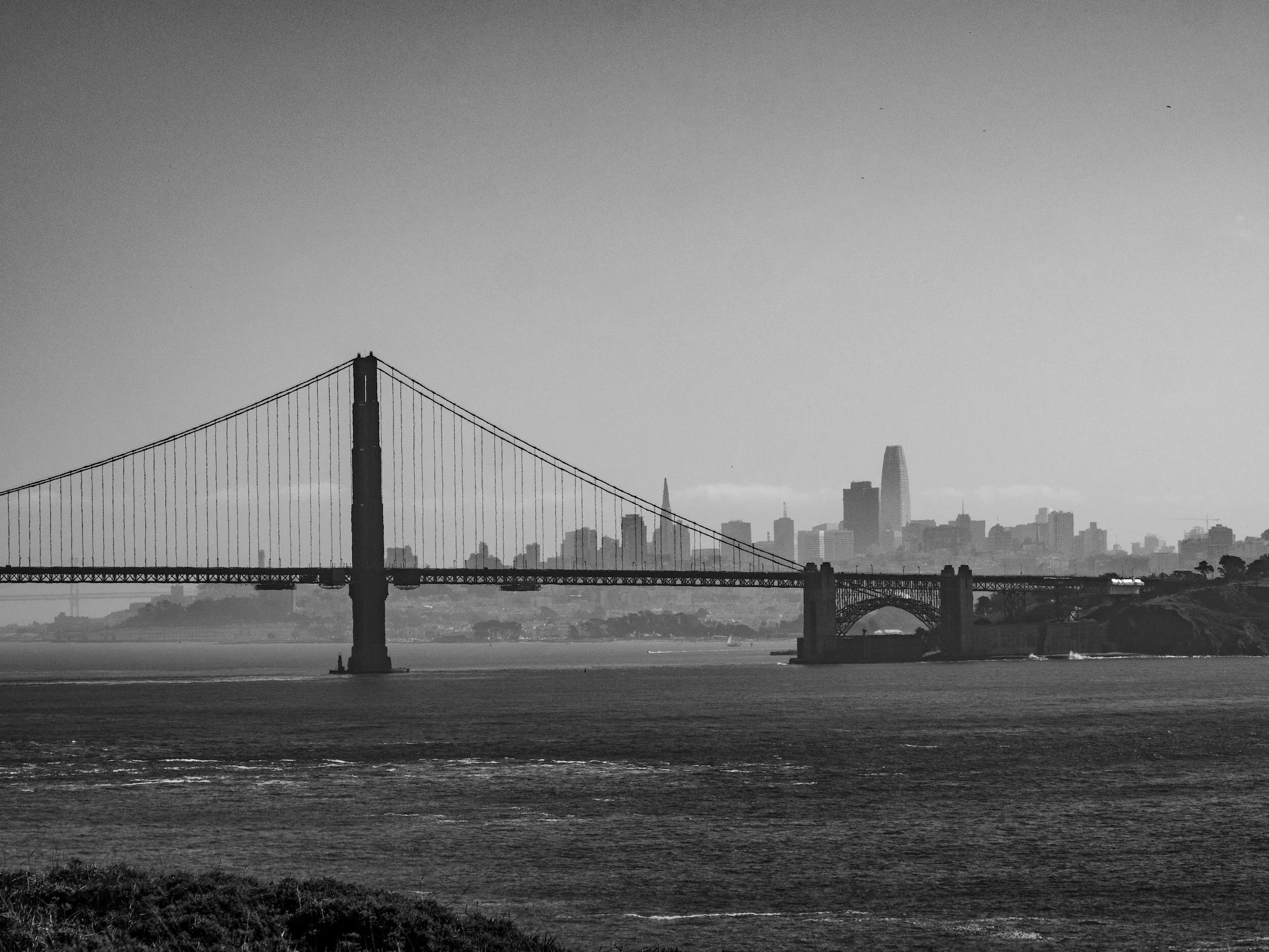 Black and white photo of the San Francisco skyline with the Golden Gate Bridge in the foreground.