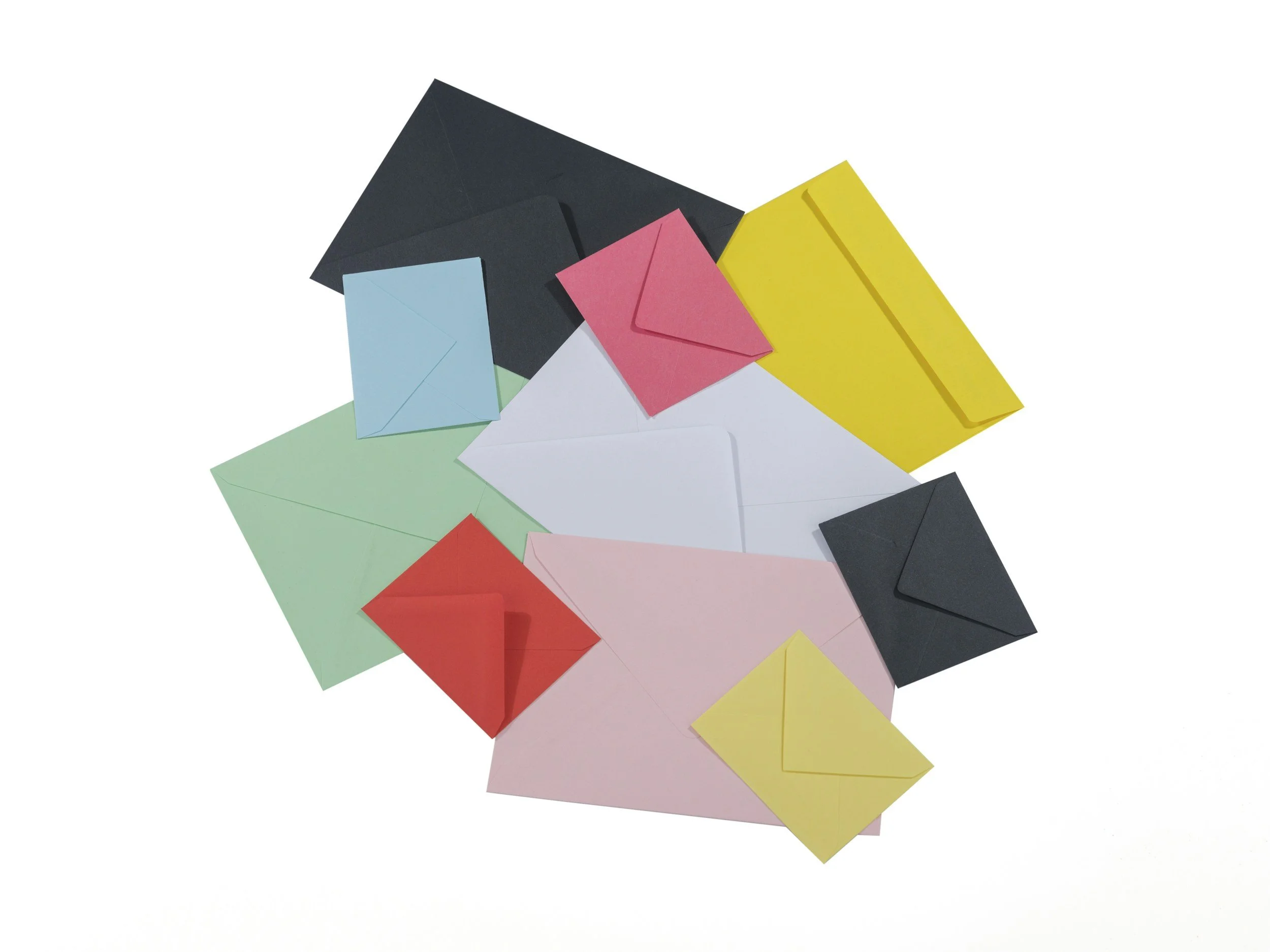 Colorful paper envelopes in pink, blue, green, yellow, black, and white arranged in a scattered pattern on a white background.