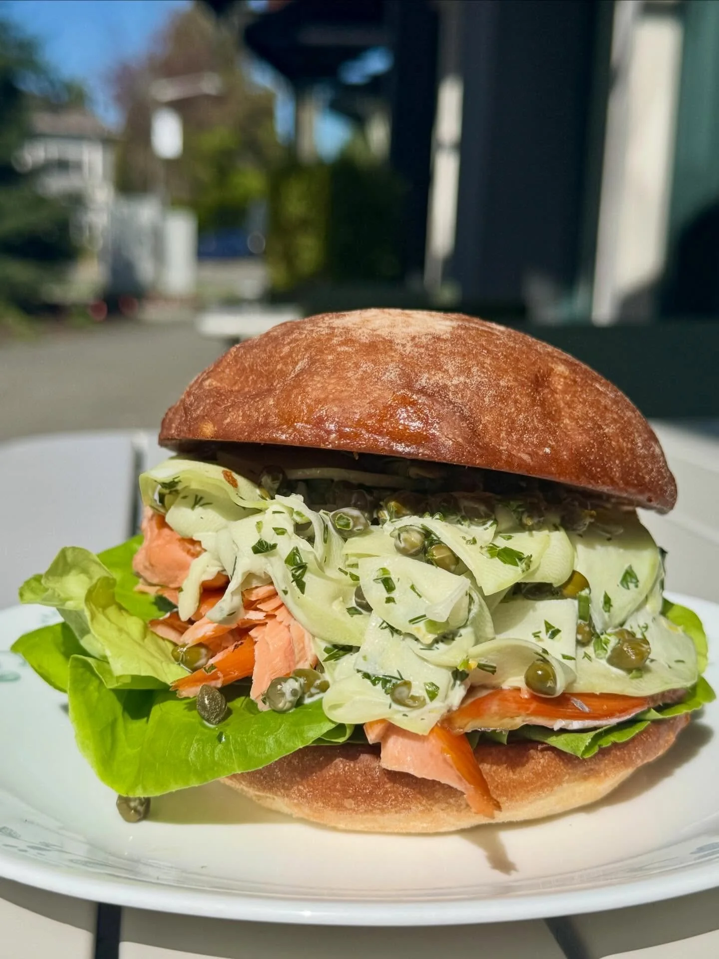 The Smoked Rainbow Trout Sandwich with crispy, seasonal butter lettuce and a bright kohlrabi slaw on a butter griddled potato bun