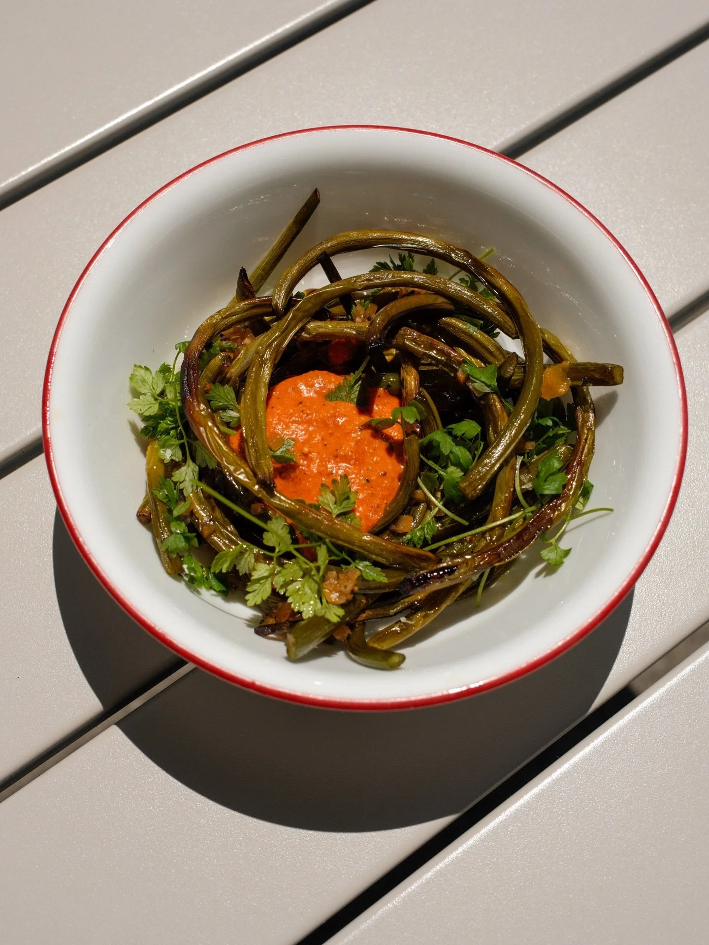 ✨ NEW ✨ side special: Roasted green garlic on top of romesco with lemon-pepper oil and chervil 🌱