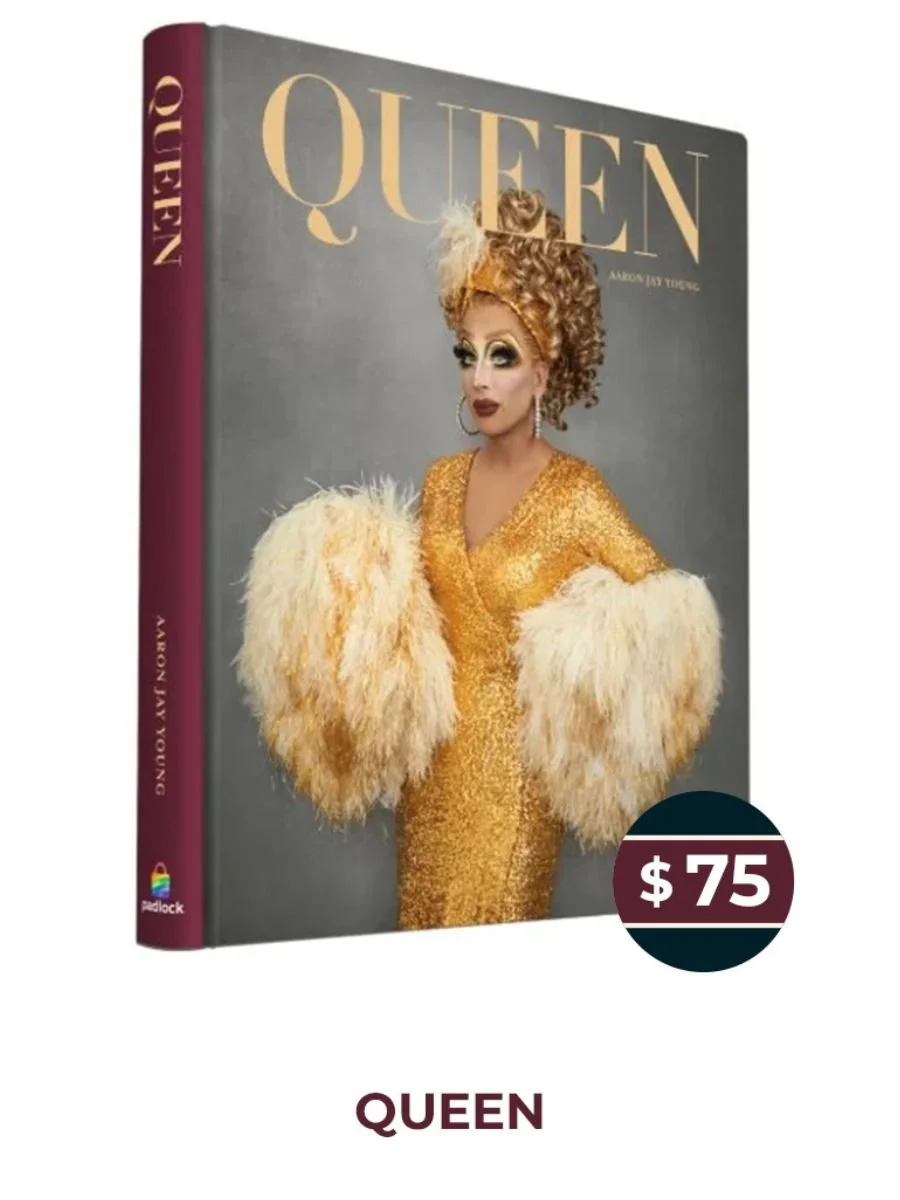 Book titled 'Queen' featuring a drag queen in a gold dress with fluffy sleeves and large earrings, with a makeup and hairstyle.