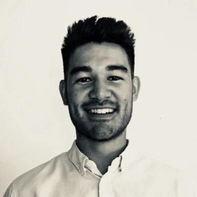 Black and white portrait of a smiling man with short hair.