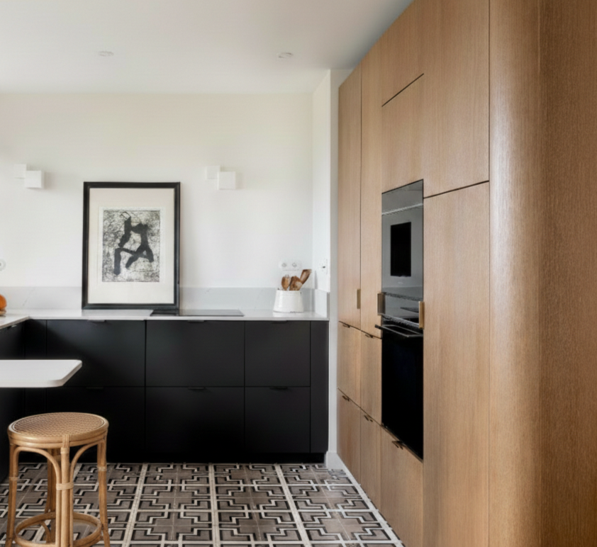 Une cuisine moderne avec des façades en chêne clair, un plan de travail blanc en marbre blanc et un sol en carreaux ciment à motifs géométriques.