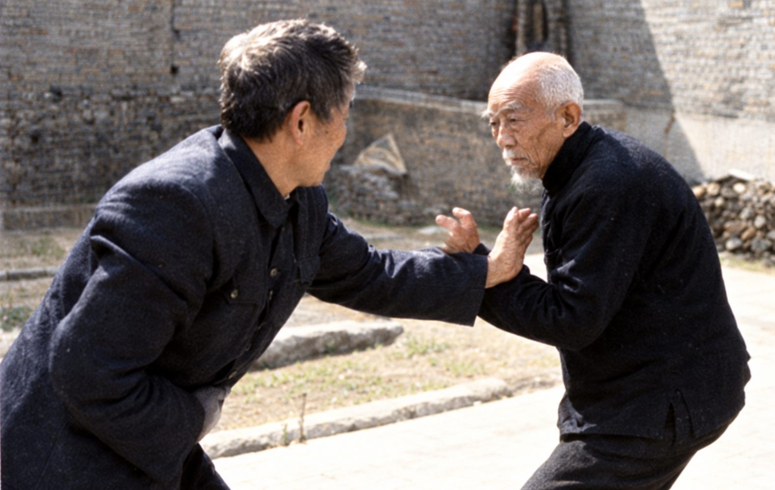 Wu Dianke practising a close-range martial arts method with a partner in a courtyard
