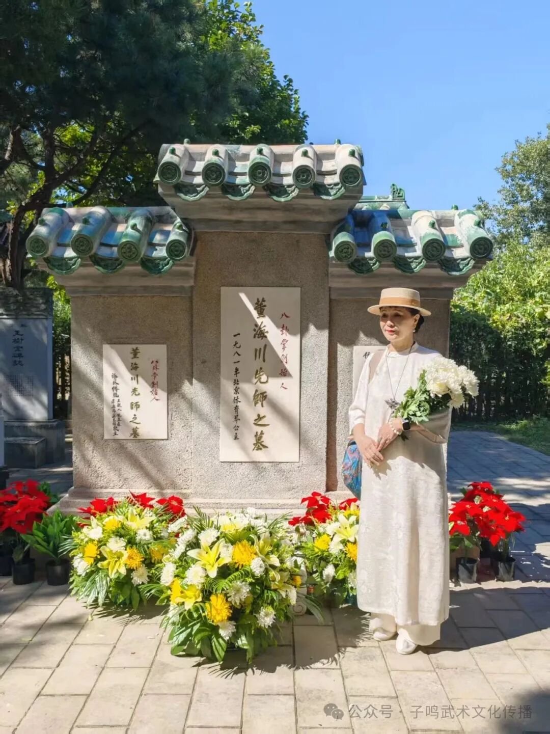 Woman standing beside Dong Haichuan’s tomb and floral arrangements