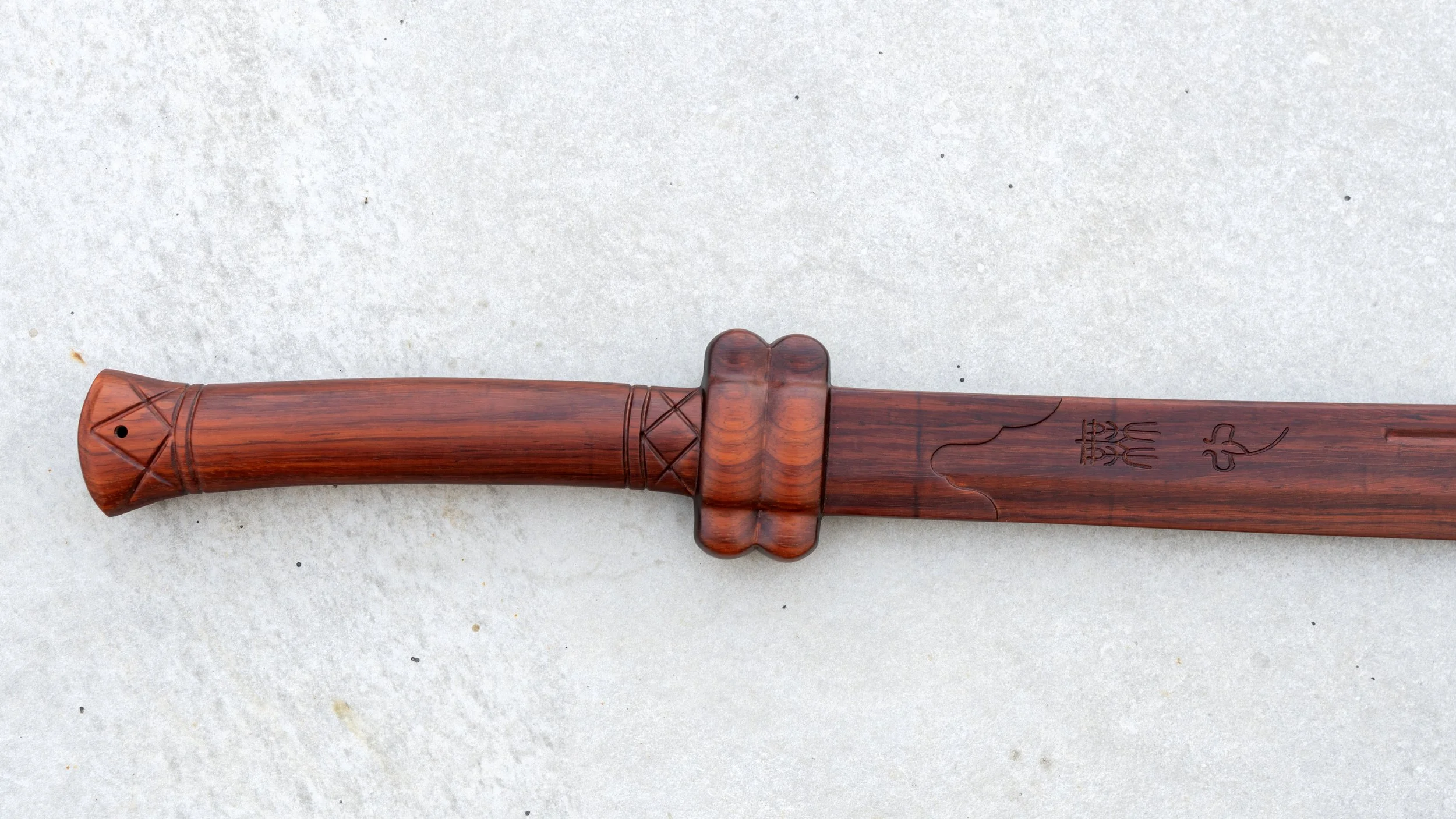 Wooden Dao handle with carved guard, flared pommel and Mu Shin engraving on the red sandalwood blade