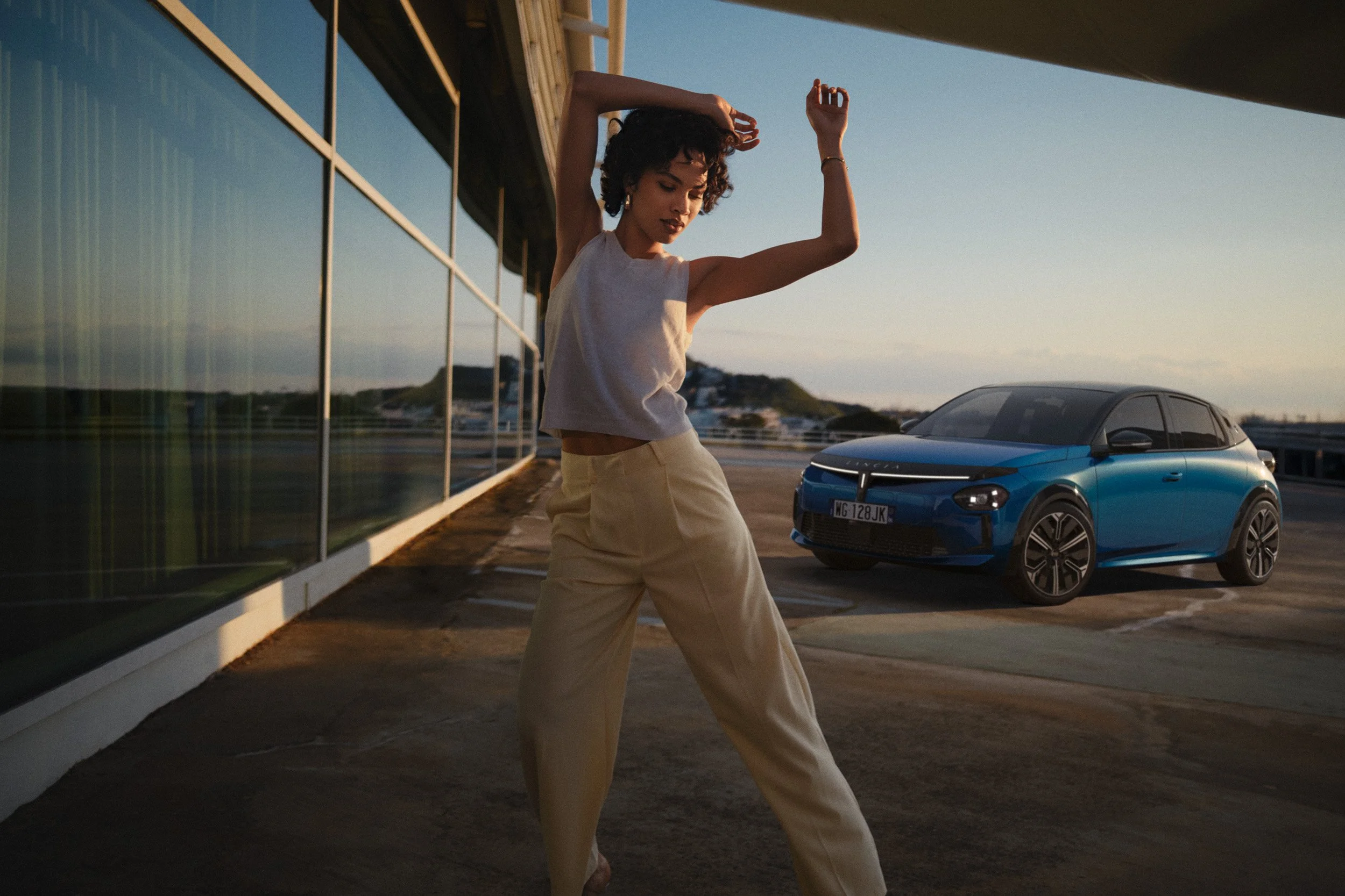 Automotive advertising image of woman on steps with Lancia Ypsilon. Automotive photography, CGI, retouching, postproduction, lifestyle