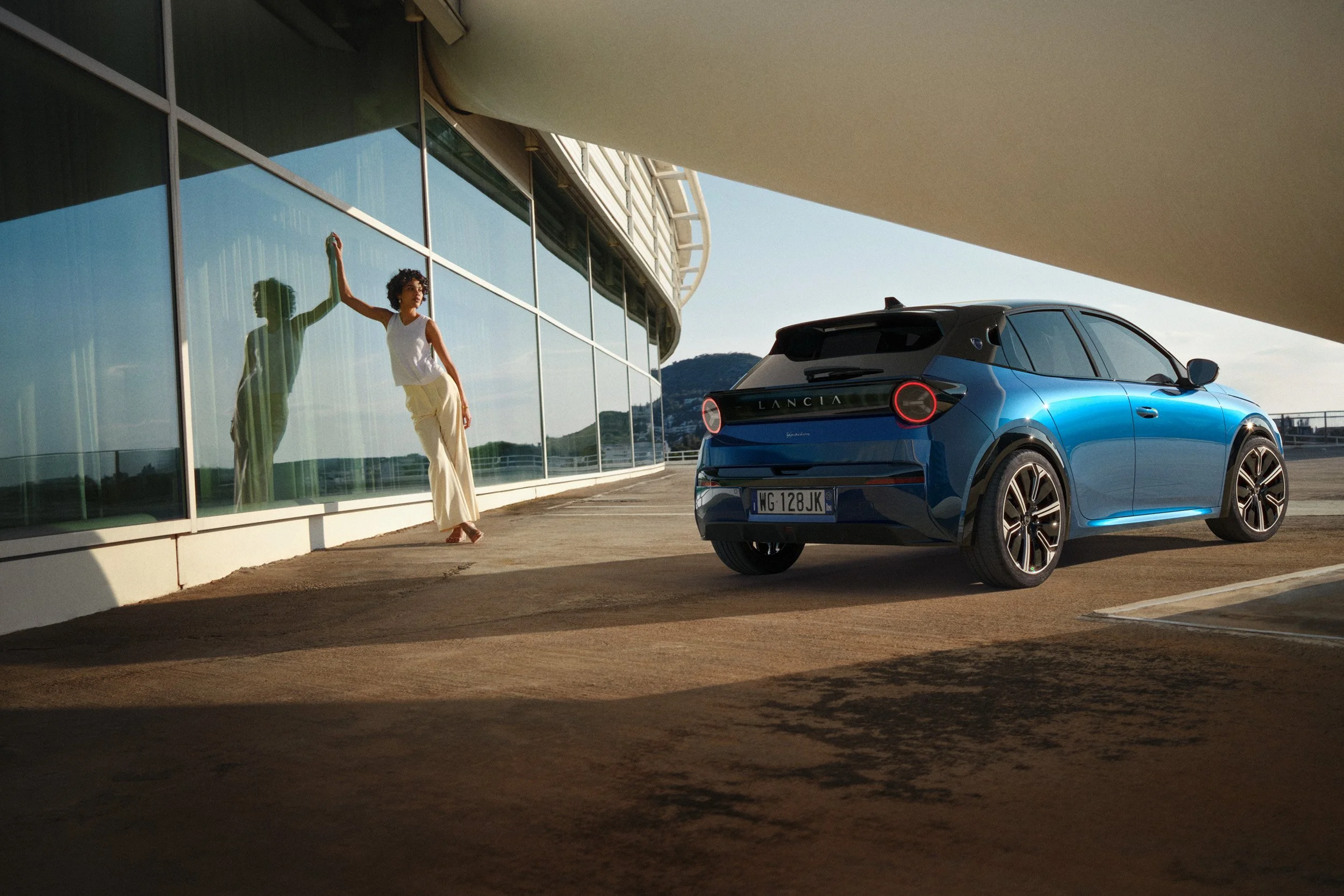 Automotive advertising image of woman on steps with Lancia Ypsilon. Automotive photography, CGI, retouching, postproduction, lifestyle
