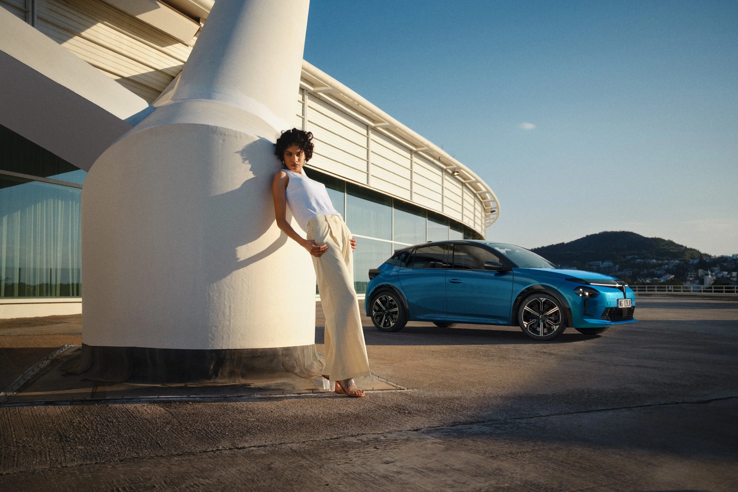 Automotive advertising image of woman on steps with Lancia Ypsilon. Automotive photography, CGI, retouching, postproduction