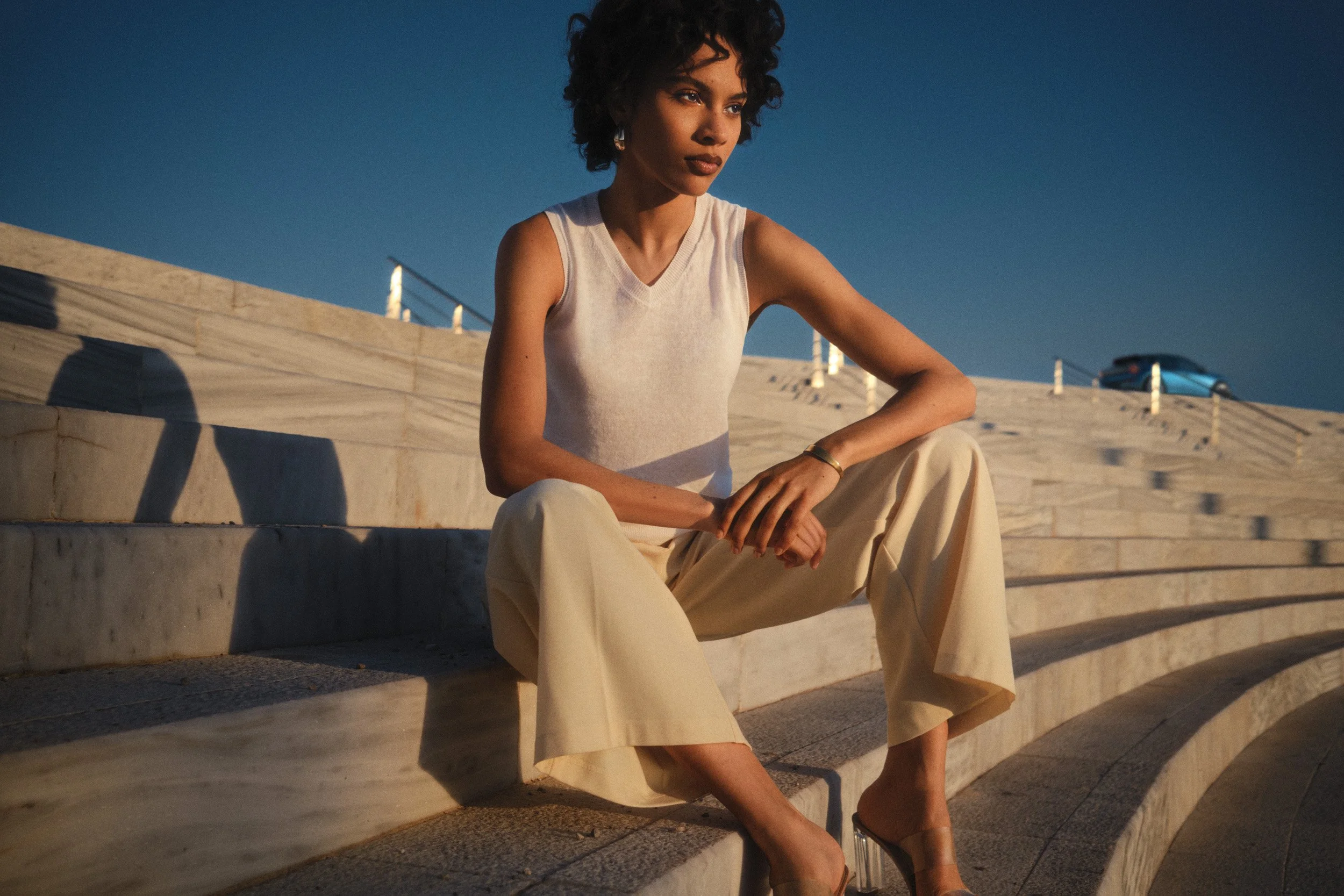 Automotive advertising image of woman on steps with Lancia Ypsilon. Automotive photography, CGI, retouching, postproduction