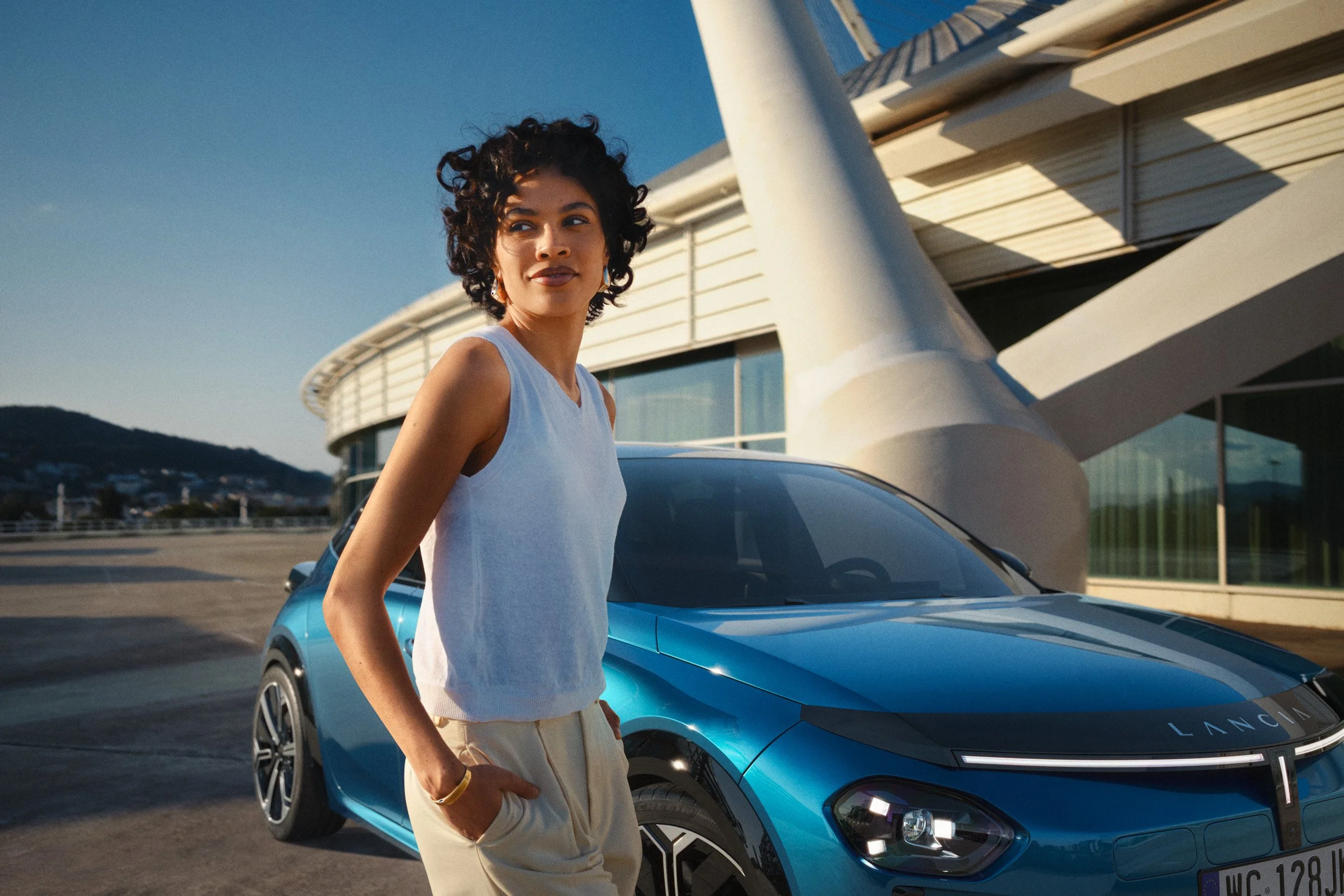 Automotive advertising image of woman on steps with Lancia Ypsilon. Automotive photography, CGI, retouching, postproduction