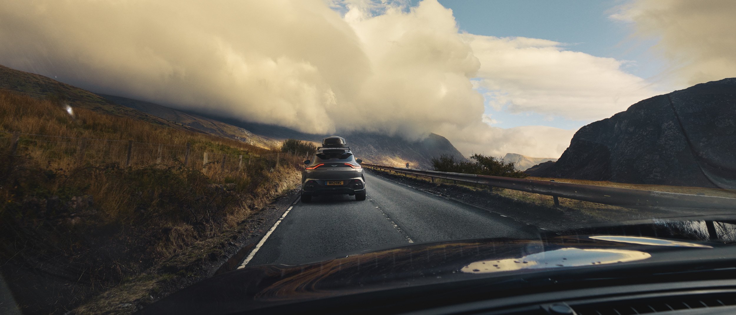 Cinematic automotive advertising image of a luxury SUV in a rugged mountain landscape demonstrating high-end CGI compositing, environment integration and post-production retouching.