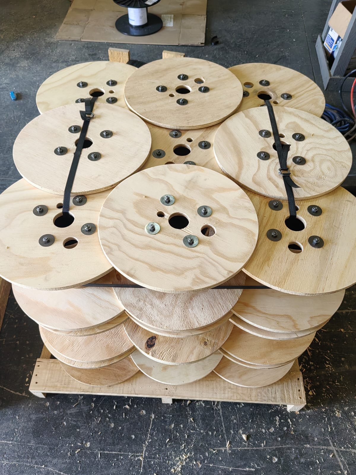 Plywood wire reels strapped onto wooden pallet